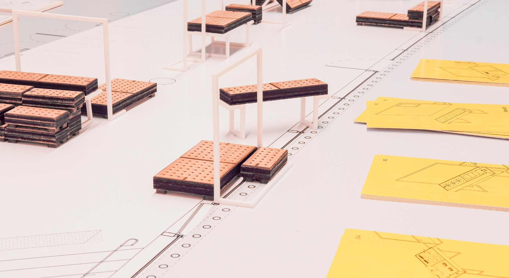 Maquette des modules perforés et des cadres blancs sur un plan, fiches jaunes à côté